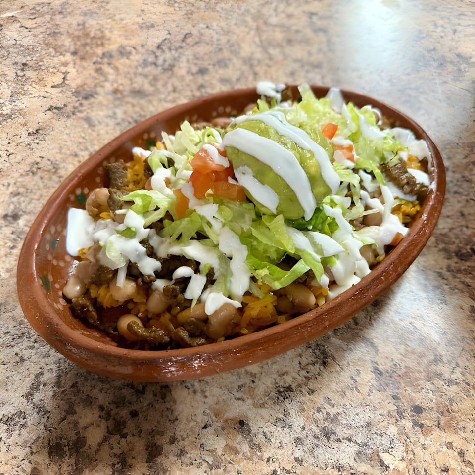 La Carreta's Mexican dish with meat, beans, rice, lettuce, tomatoes, guacamole, and sour cream.